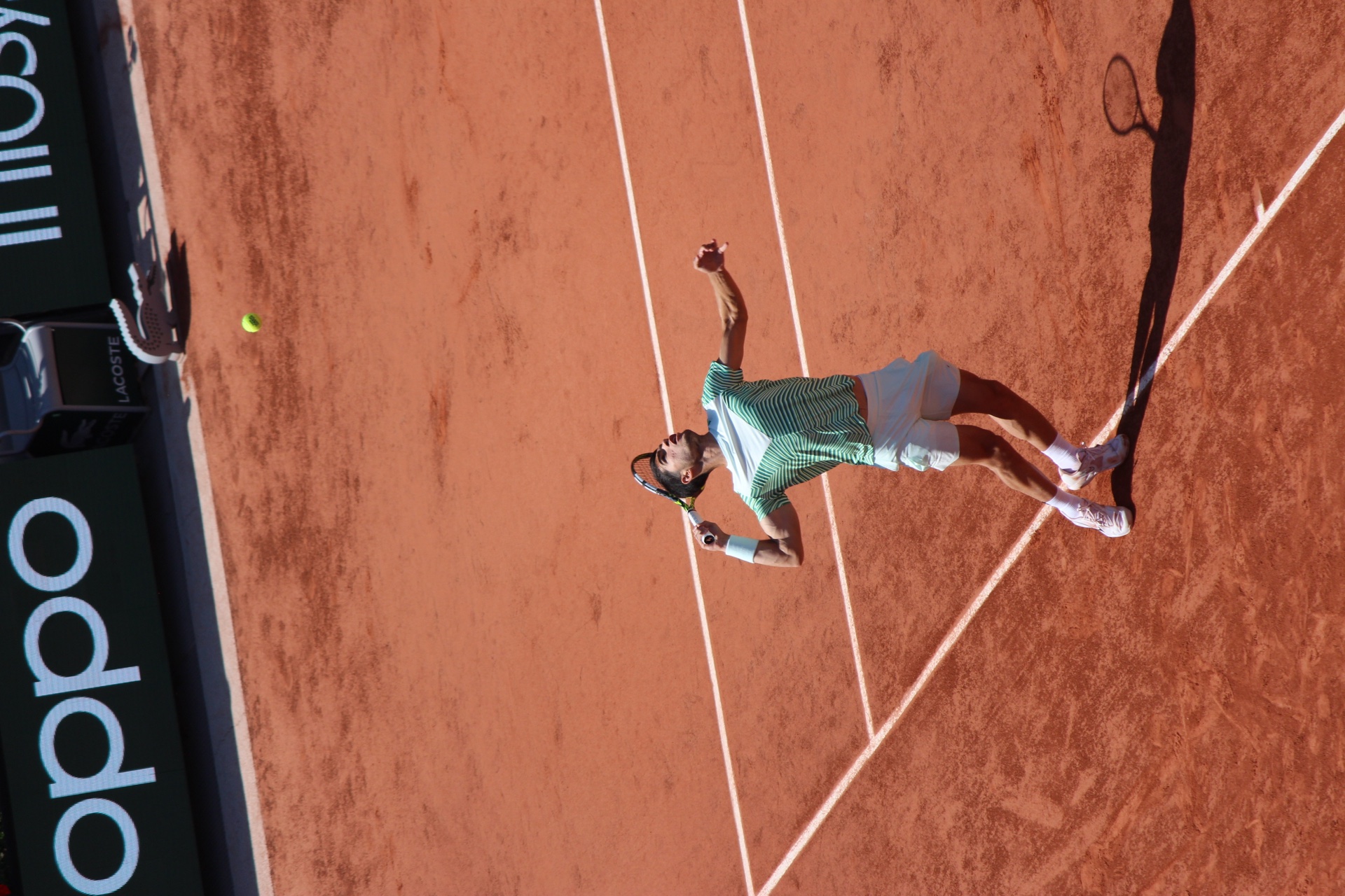 Carlos Alcaraz preparing to serve at Roland-Garros in 2023.